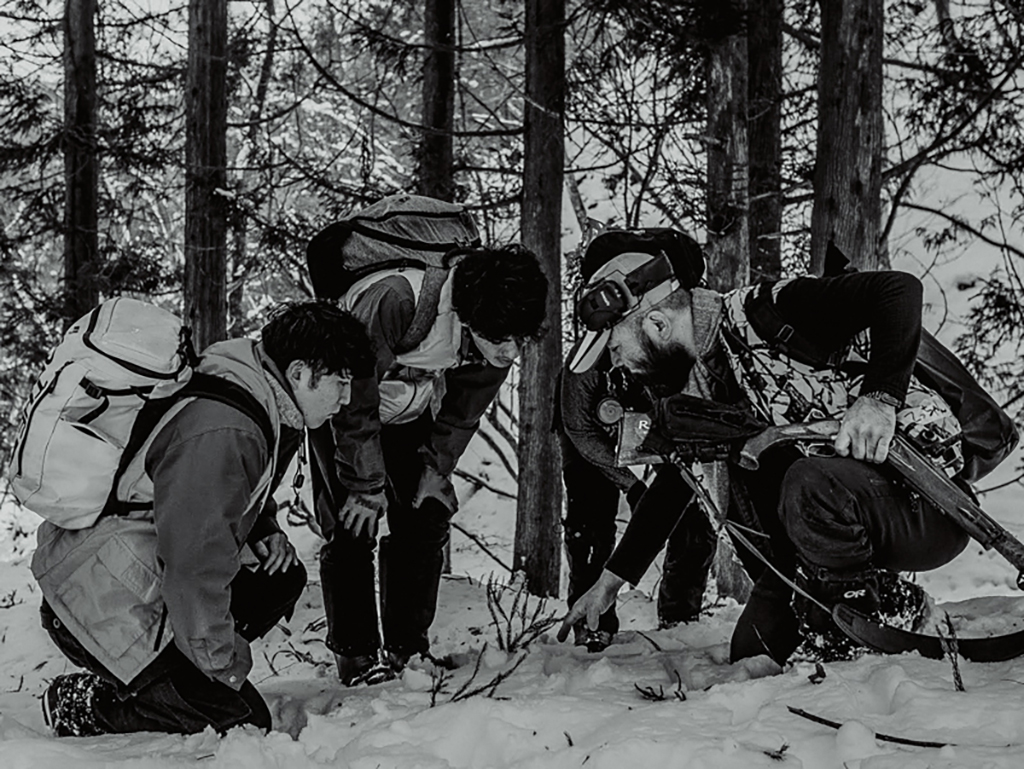獣の痕跡を説明する松川と話を聞く参加者