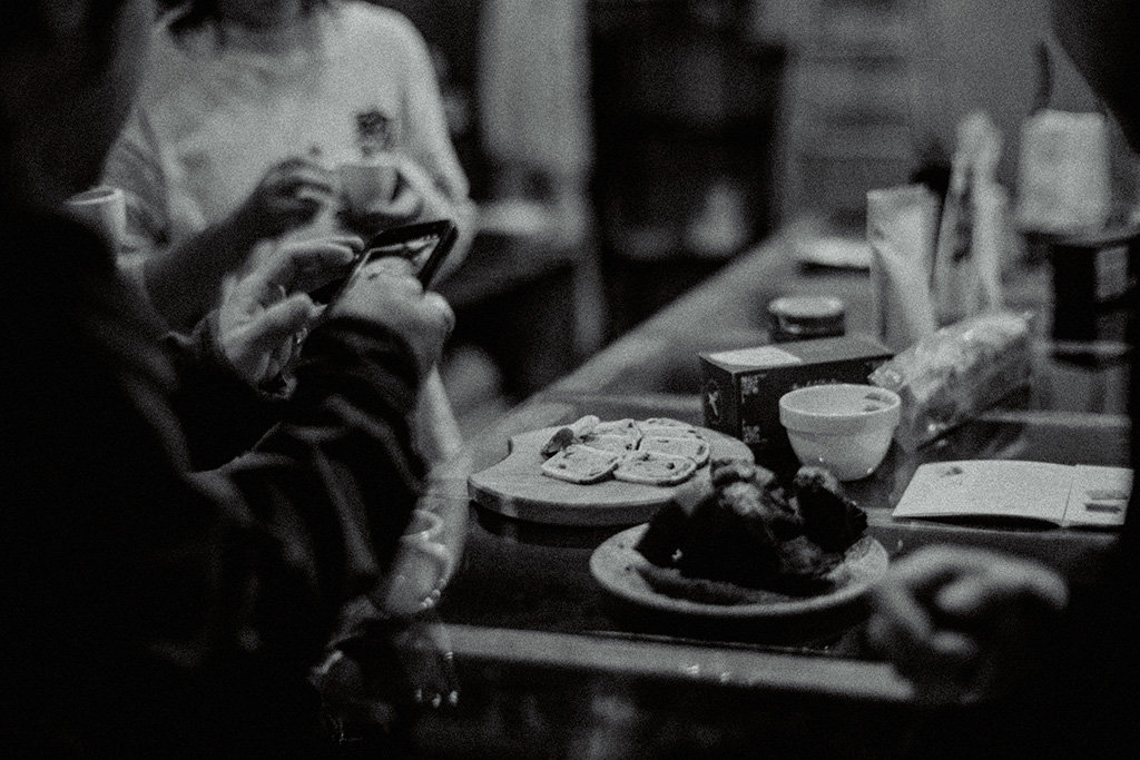並べたお菓子を撮影する人