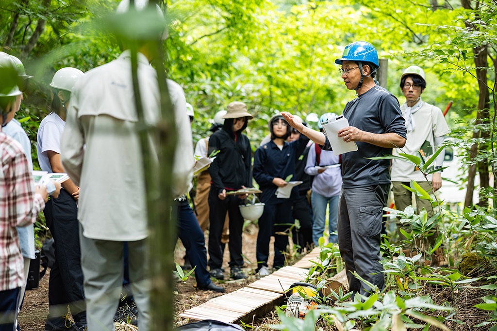 広葉樹の森で学生に説明をするもの森代表の山口さん